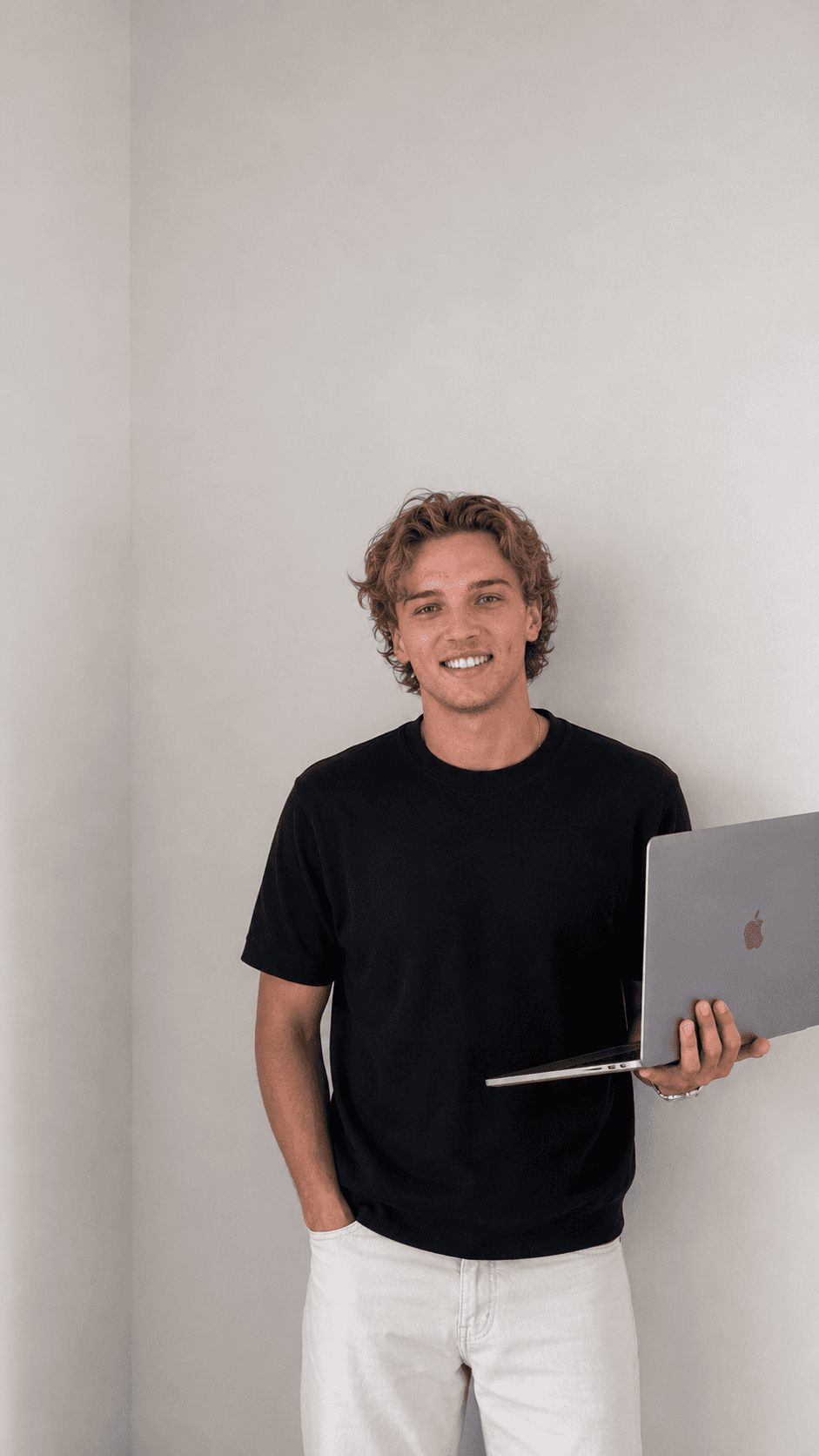 Baxter Hanley, founder of Baxoptimized, holding a laptop